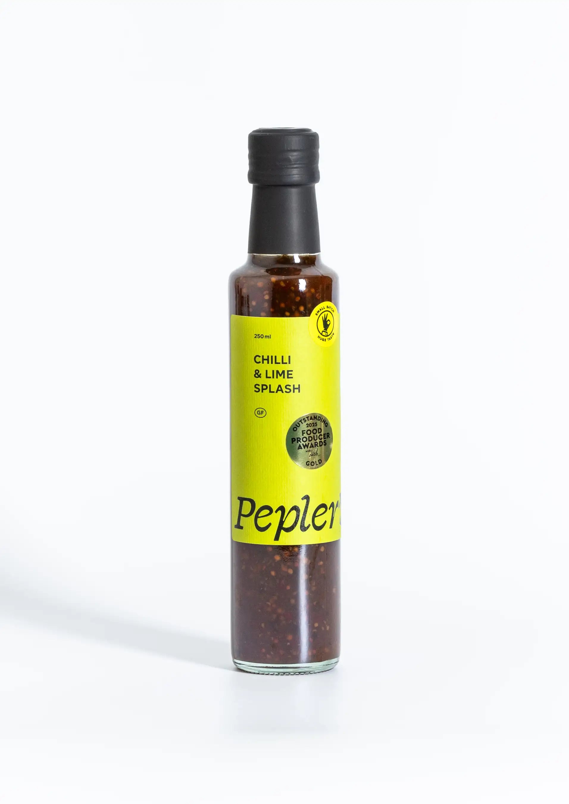 A bottle of Pepler's Chilli & Lime Splash sauce, featuring a vibrant yellow label. The bottle holds 250 ml of a reddish-brown sauce filled with visible red chili flakes. The label displays the product name "Chilli & Lime Splash," along with a symbol indicating it is made in small batches. The background is plain white, highlighting the product.