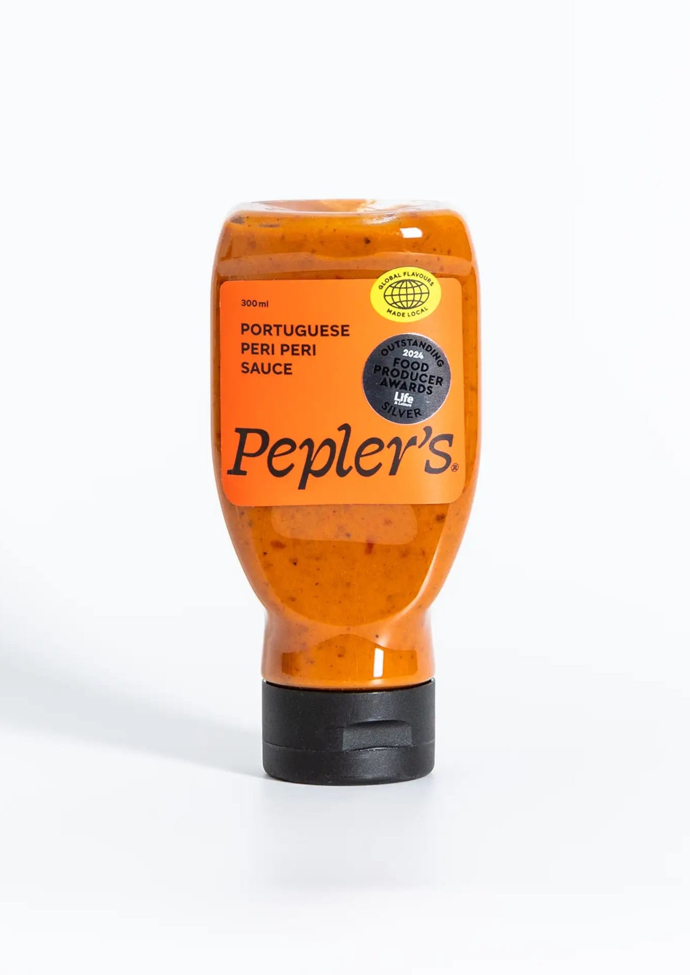 A bottle of Pepler's Portuguese peri peri sauce, featuring a bold red label with the text "PORTUGUESE PERI PERI SAUCE" and a circular logo stating "GLOBAL FLAVOURS MADE LOCAL." The bottle has a squeezable design and holds 300 ml of sauce. The background is simple and neutral, enhancing the visibility of the product.