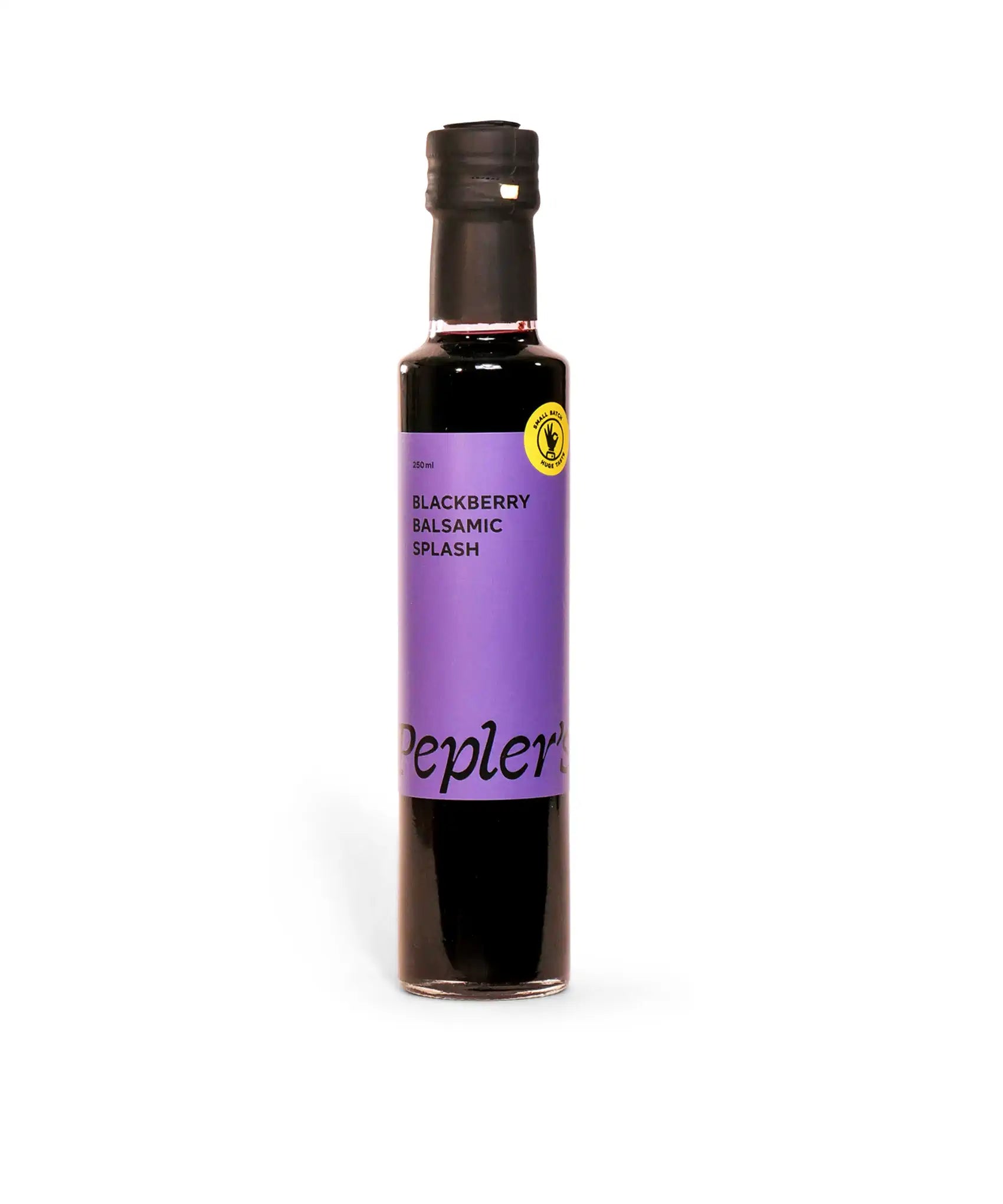 A bottle of Pepler's Blackberry Balsamic Splash is displayed against a white background. The bottle is 250 ml in size, featuring a purple label with black text that reads "BLACKBERRY BALSAMIC SPLASH." A yellow circular seal indicating "SMALL BATCH" is also present on the label. The bottle has a black cap and a glossy finish, showcasing its rich, dark contents.