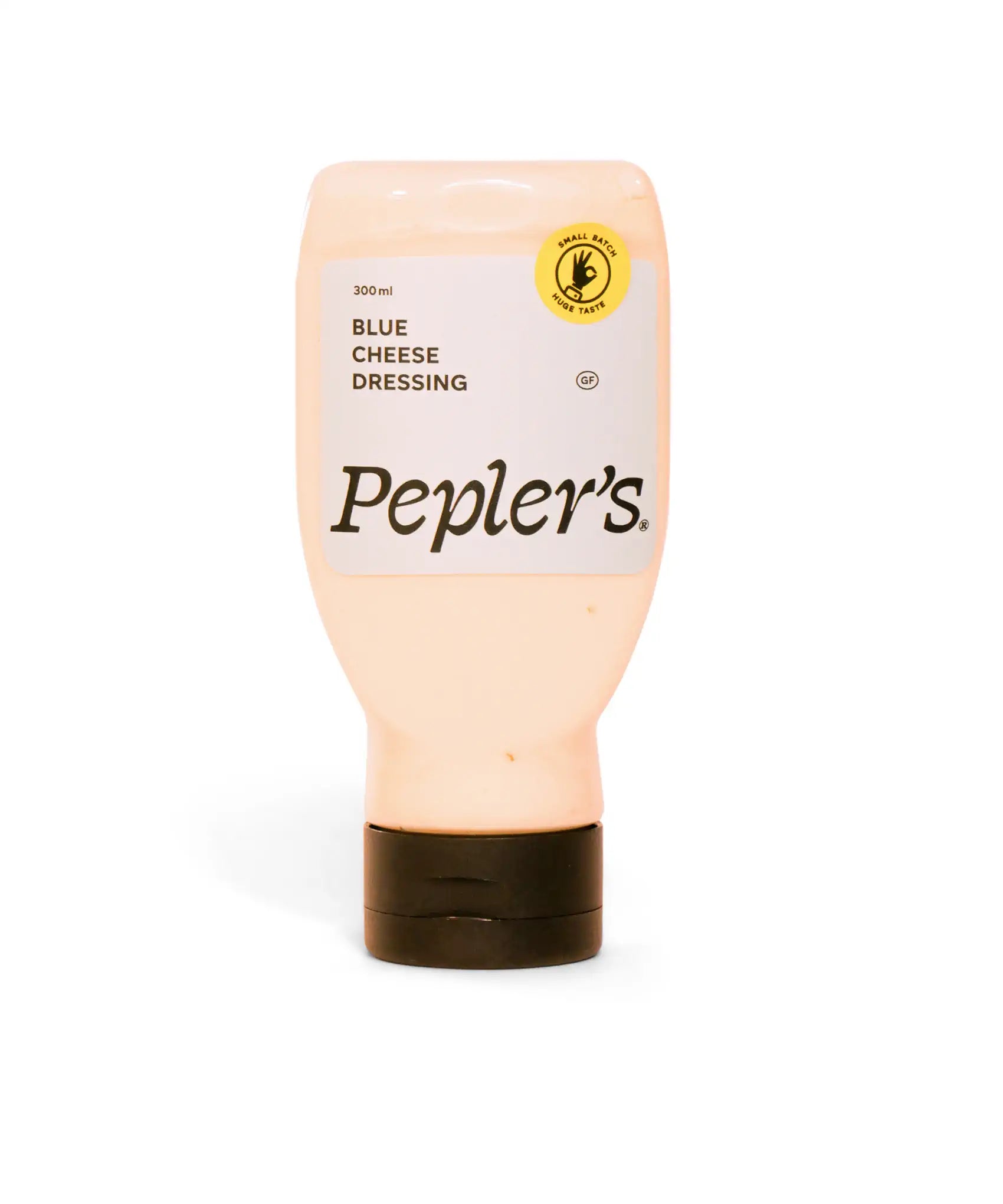 Bottle of Pepler's blue cheese dressing, 300 ml, featuring a label with the product name and a gluten-free symbol. The bottle is primarily light tan with a black cap and is set against a soft white background.
