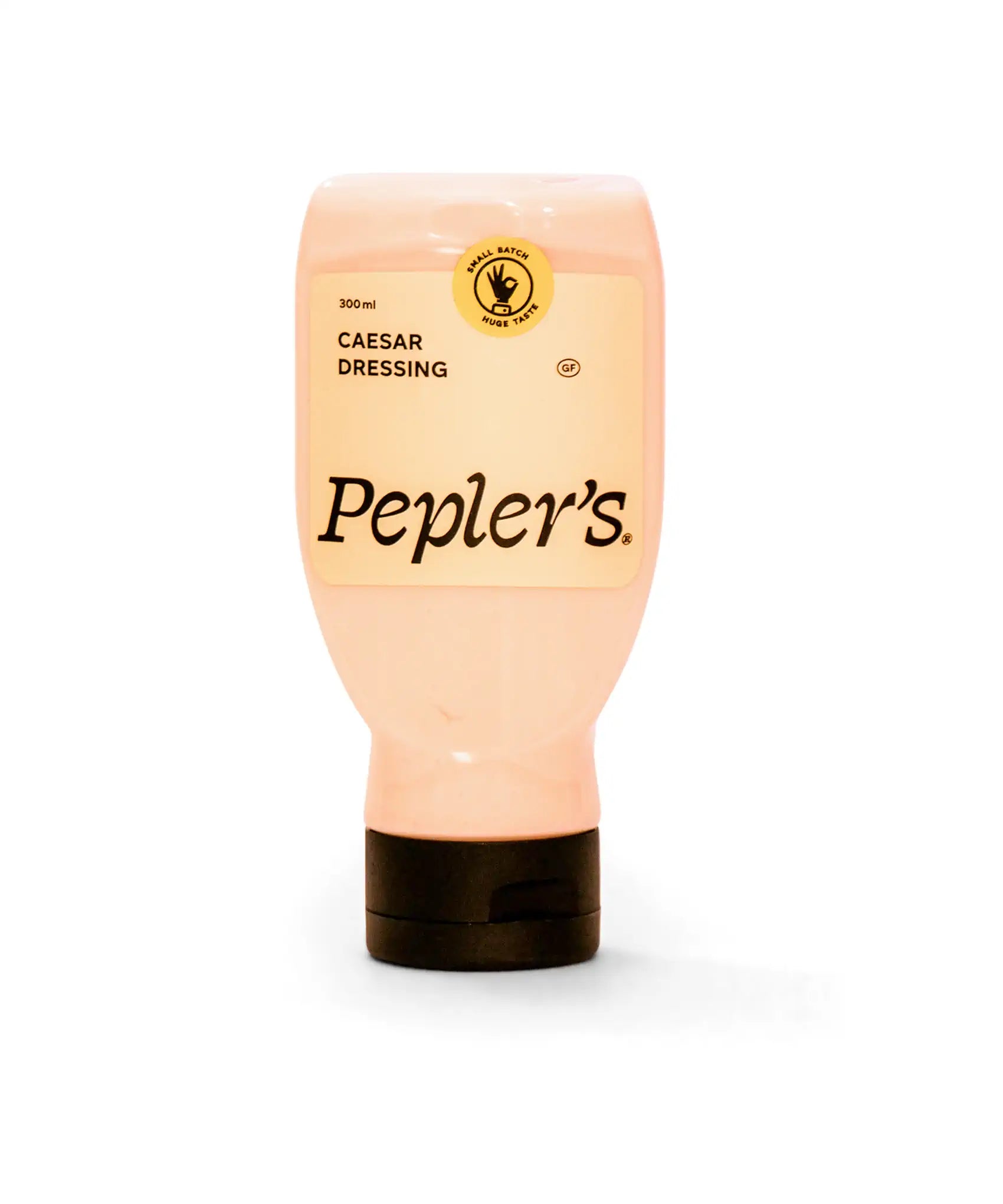 A squeeze bottle of Pepler's Caesar dressing, featuring a pale pink colour and a black cap. The label indicates a volume of 300ml and highlights the product as gluten-free with a "small batch, huge taste" seal. The brand name "Pepler's" is prominently displayed in a stylised font.