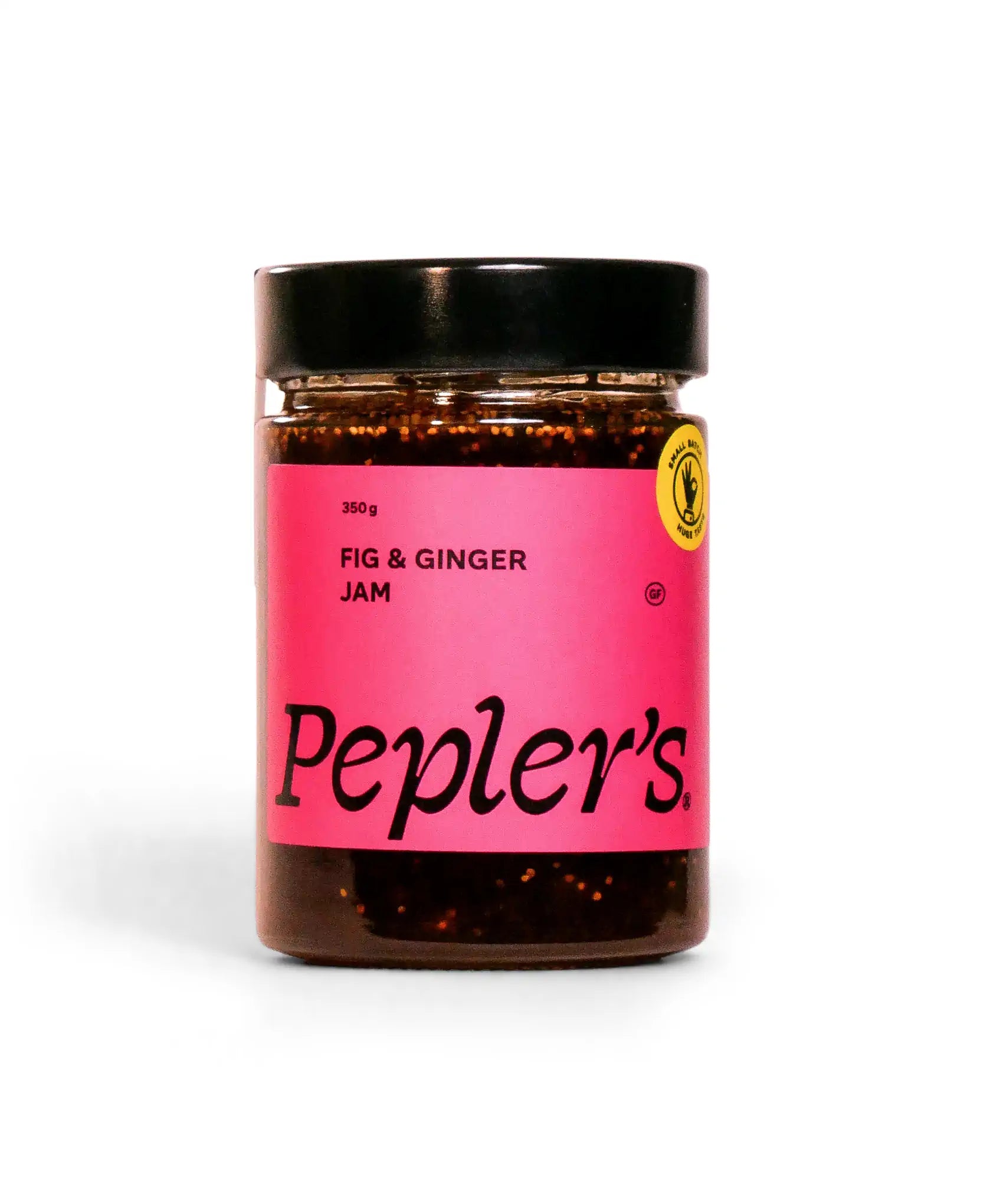 A jar of Pepler's Fig & Ginger Jam with a pink label, featuring the brand name "Pepler's" prominently displayed. The jar weighs 350 grams and is sealed with a black lid. The background is plain white, emphasising the product's vibrant colours.