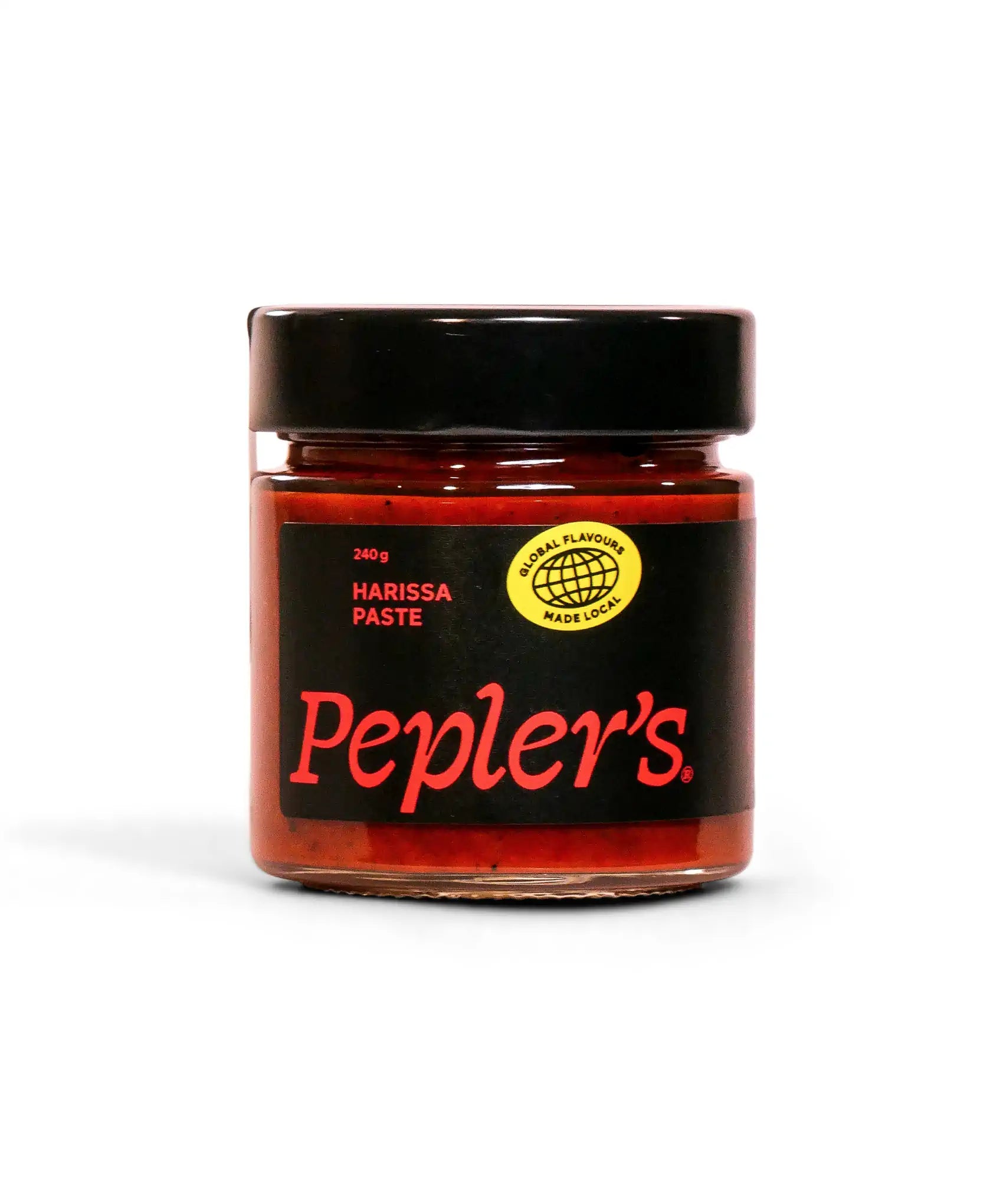 A jar of Pepler's harissa paste, weighing 240 grams, featuring a black lid and a label with bold red lettering on a black background. The label includes a circular yellow emblem stating "GLOBAL FLAVOUR MADE LOCAL." The jar is displayed against a plain white background, highlighting its contents.