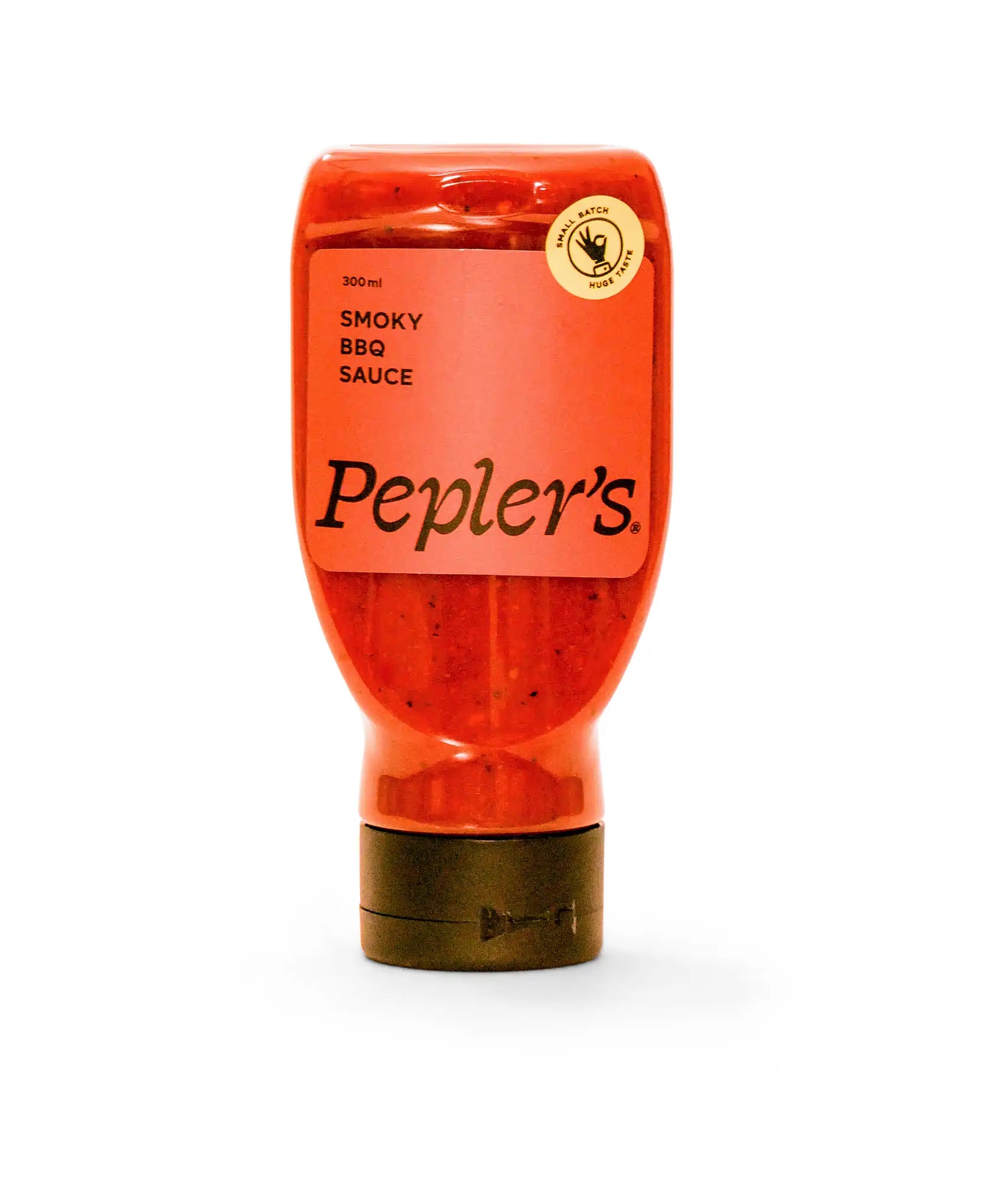 A bottle of Pepler's Smoky BBQ Sauce, labeled prominently in orange on a transparent plastic bottle. The bottle is 300 ml and features a black cap at the bottom, with a circular emblem indicating "Small Batch, Huge Taste." The background is plain white, emphasising the product.